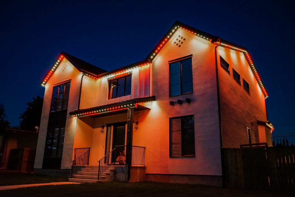 Home illuminated with orange and white permanent lights for Halloween